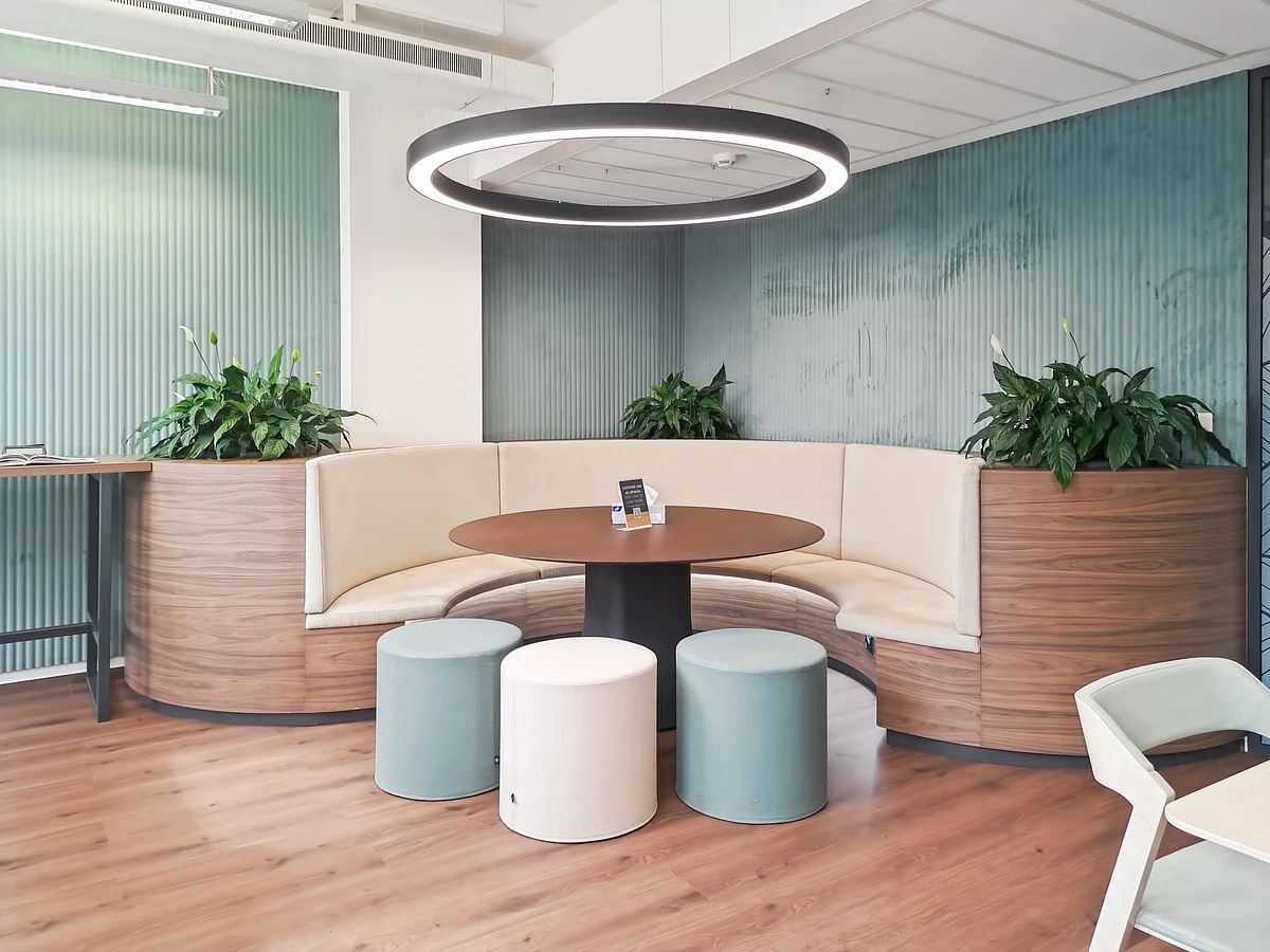 Curved banquette seating with plants for informal meetings